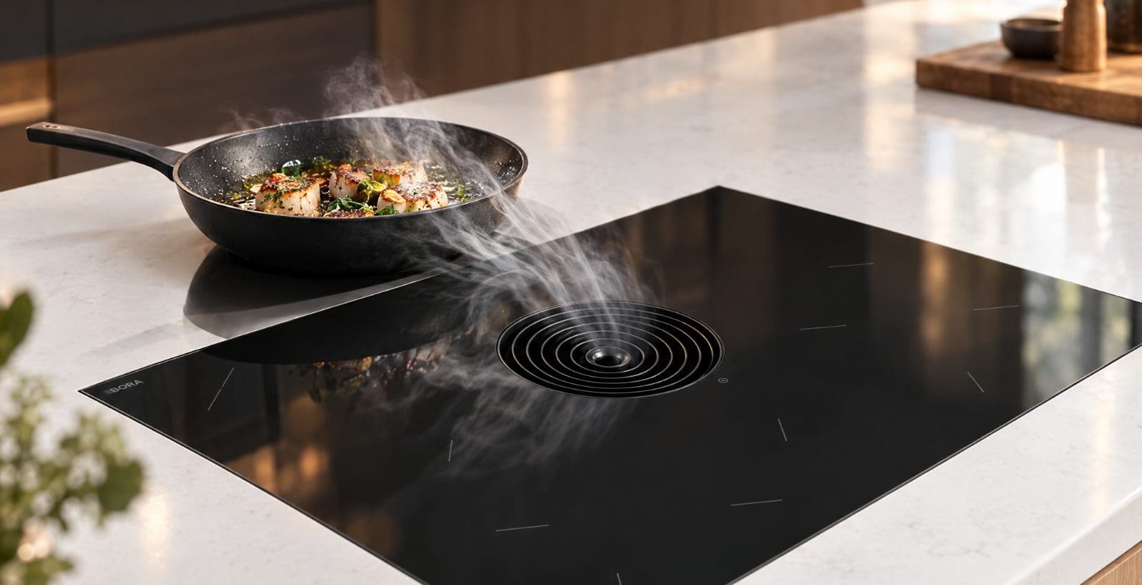 BORA hob with built-in extractor pulling steam down from a frying pan on a kitchen island